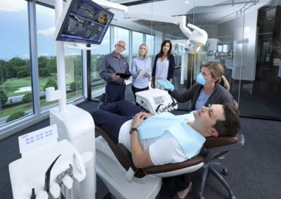 Dentsply Sirona Academy dental hygenist shows patient x-rays on interactive displays