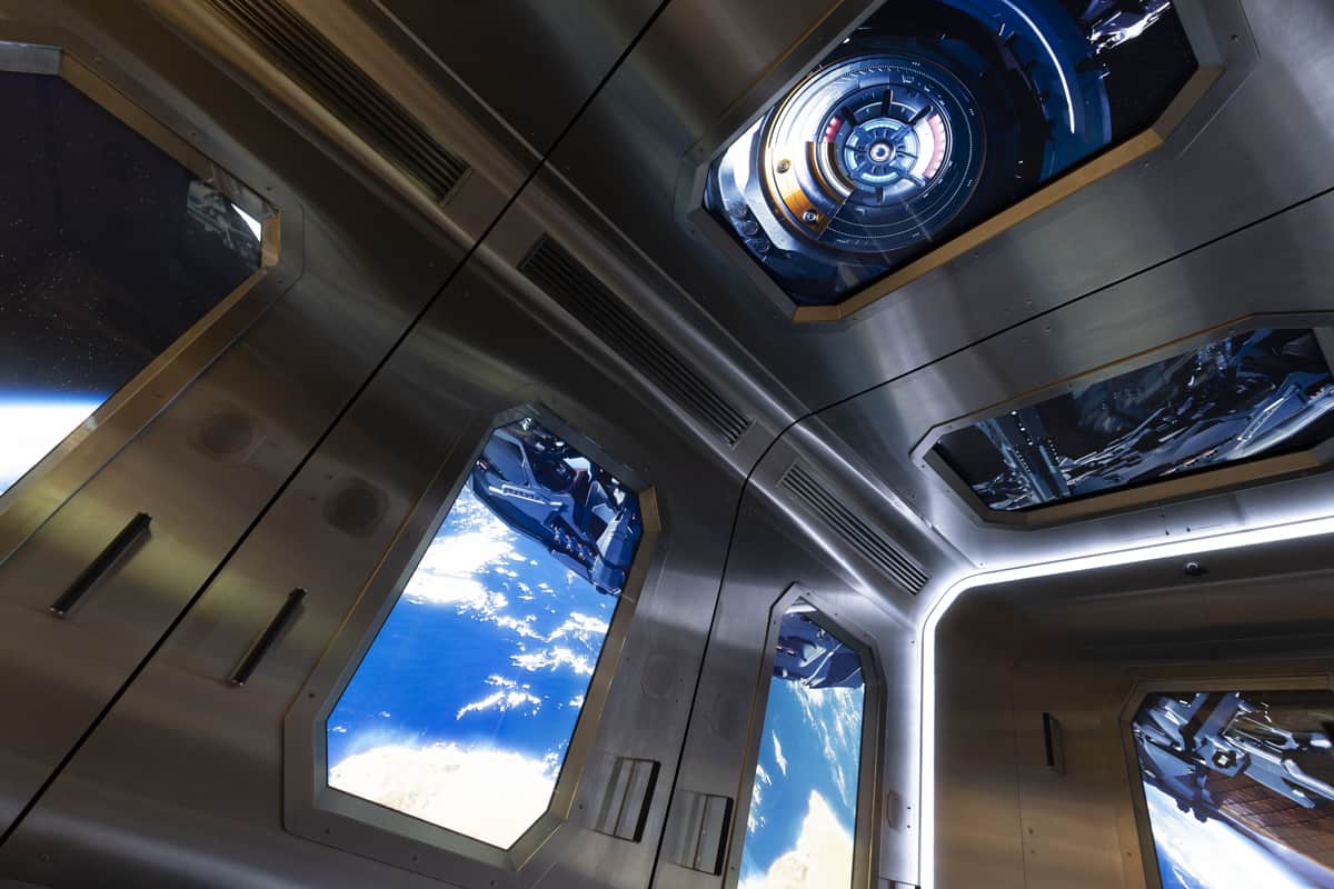 Futuristic spacecraft interior: metallic walls, large windows with Earth view, circular hatch ceiling, sleek design, natural light.