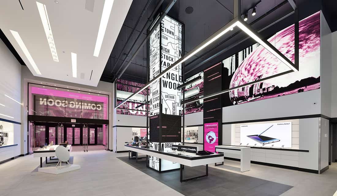 Modern retail: sleek interior, digital graphics, interactive table; pink storefront with COMING SOON in bold. Bright & spacious.