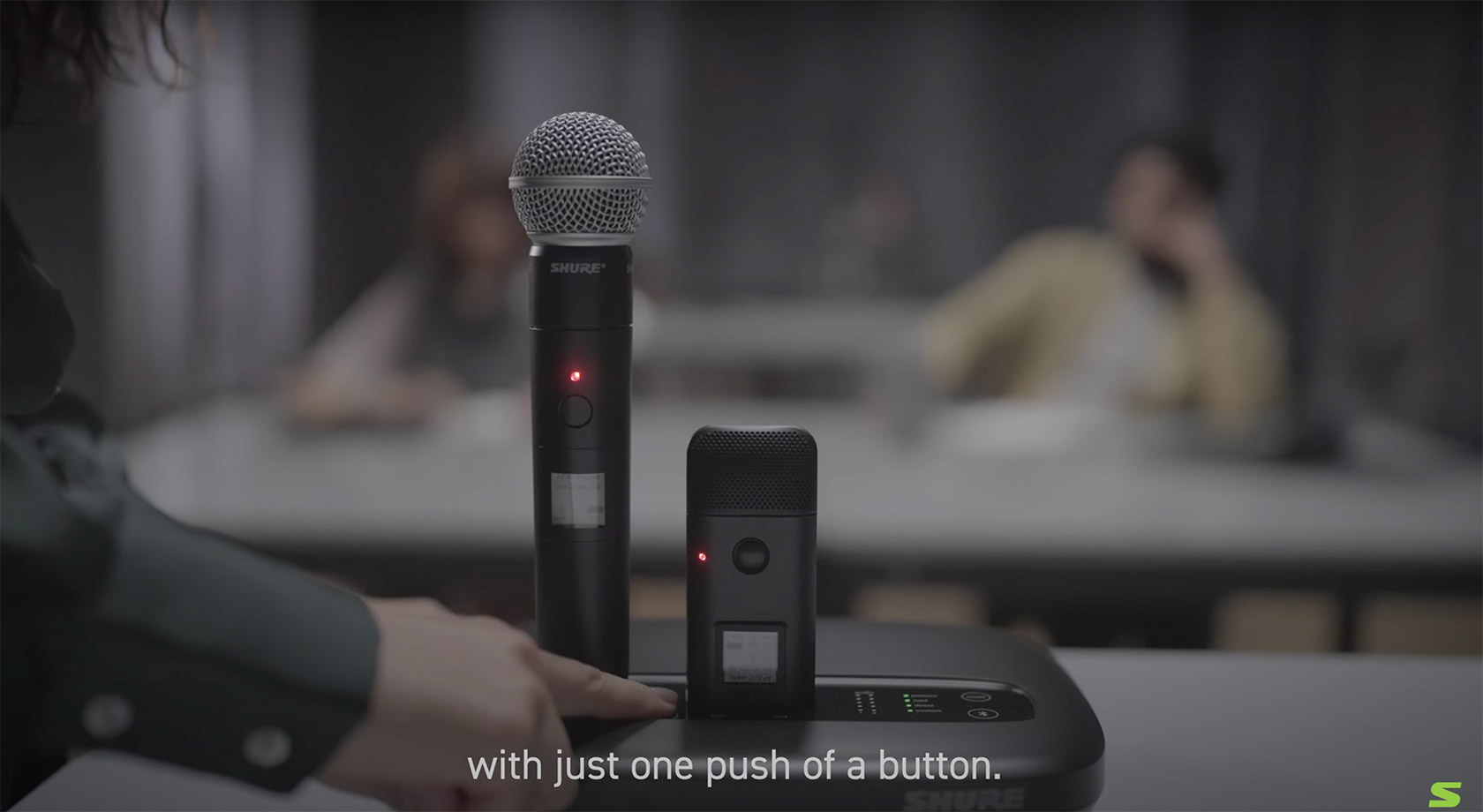 Conference call device on table whilst a person from the side is pressing a button.