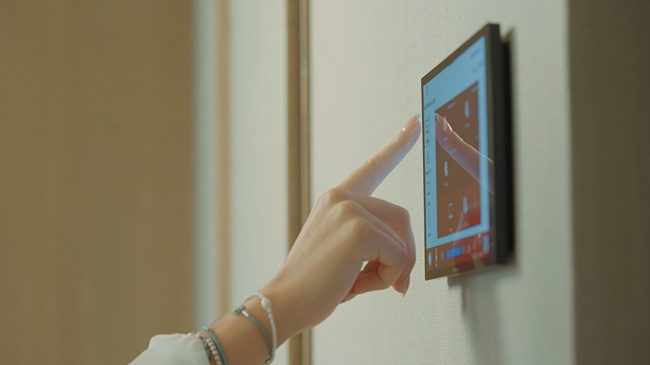 Mano que señala hacia un panel de control instalado en la pared